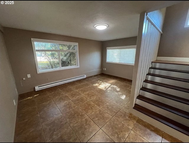 tiled empty room with a baseboard heating unit, stairway, a textured ceiling, and baseboards