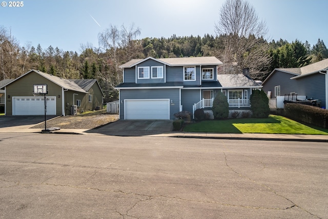 traditional home with a porch, driveway, an attached garage, and a front yard