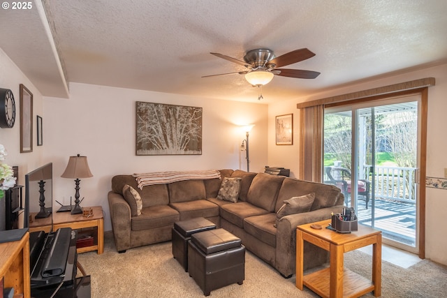 living room featuring light colored carpet, a textured ceiling, and a ceiling fan