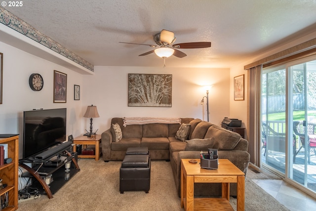 carpeted living room featuring a textured ceiling and a ceiling fan