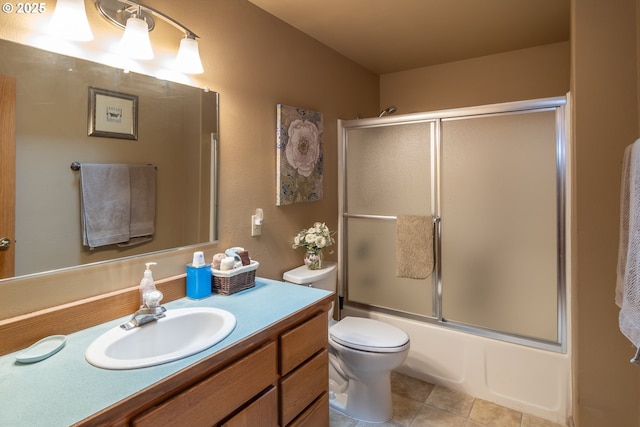 full bath featuring vanity, toilet, tile patterned flooring, and bath / shower combo with glass door