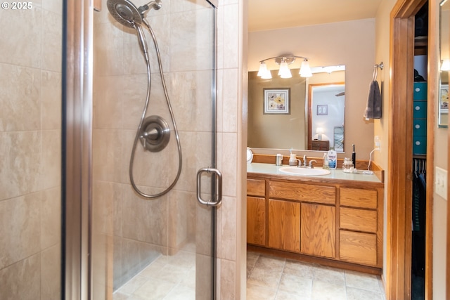 ensuite bathroom featuring connected bathroom, a stall shower, and vanity