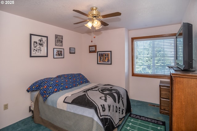 carpeted bedroom with a textured ceiling and ceiling fan