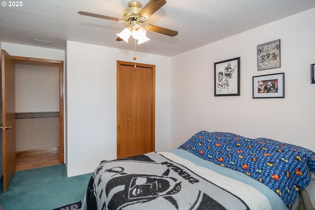 bedroom with visible vents, a textured ceiling, a closet, carpet flooring, and ceiling fan