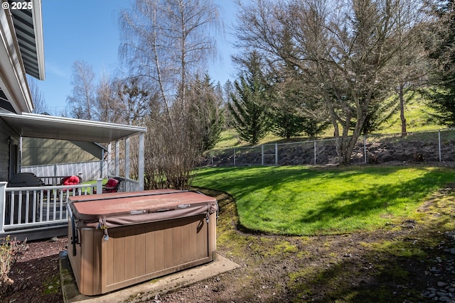 view of yard featuring fence and a hot tub