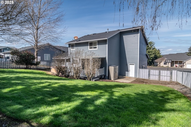 rear view of property featuring a yard, a chimney, and a fenced backyard