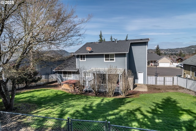 back of house with a yard, a pergola, and a fenced backyard