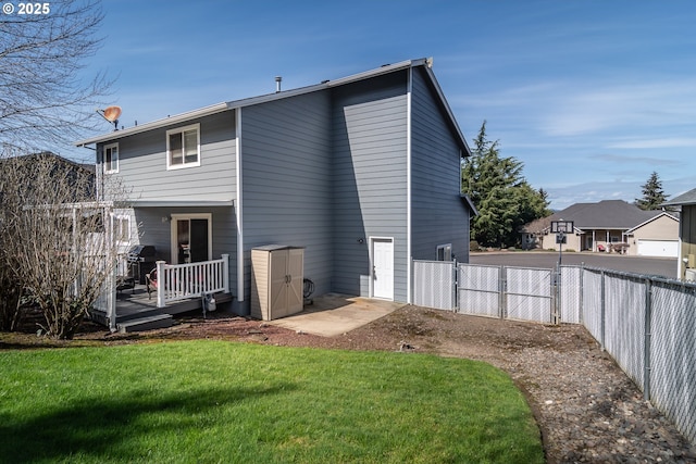 back of house featuring a gate, a wooden deck, a yard, and fence