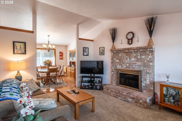 carpeted living room featuring a fireplace, lofted ceiling, and an inviting chandelier