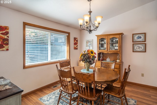 dining room with visible vents, baseboards, a notable chandelier, and light wood finished floors