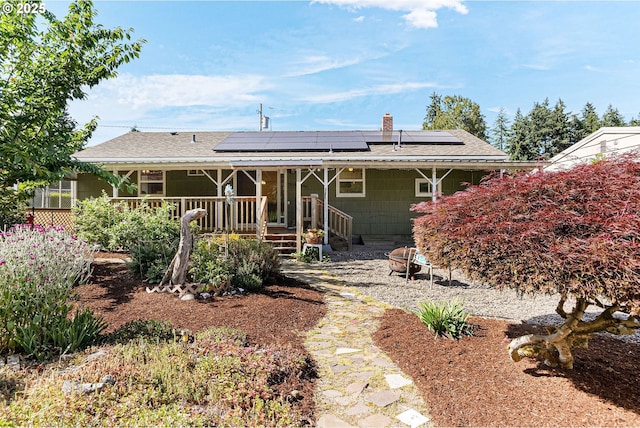 1052 Shamrock Dr SE, Salem, OR 97302 - back of house featuring solar panels, a shingled roof, and a chimney