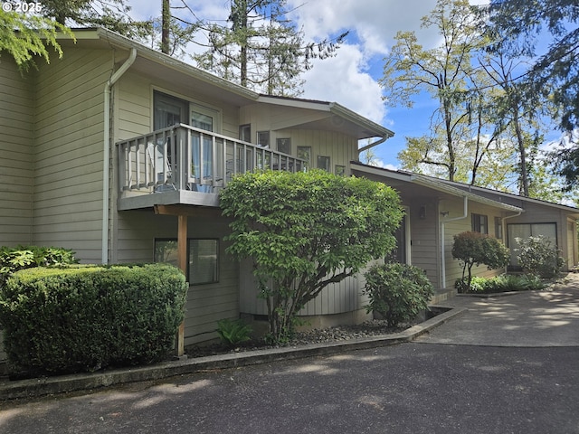view of side of home with a balcony and a garage