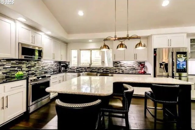 3484634844 Matthews Rd, Eugene, OR 97405 - kitchen featuring appliances with stainless steel finishes, a center island, recessed lighting, a breakfast bar, and backsplash