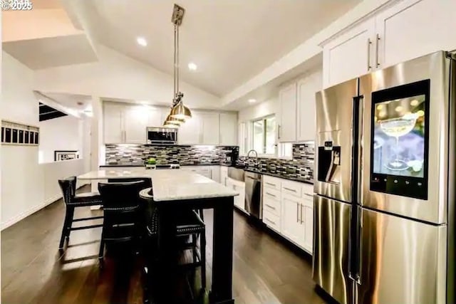 3484634844 Matthews Rd, Eugene, OR 97405 - kitchen with stainless steel appliances, vaulted ceiling, decorative backsplash, white cabinets, and a center island
