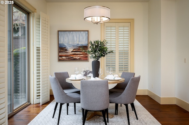 dining room featuring dark wood-style flooring and baseboards