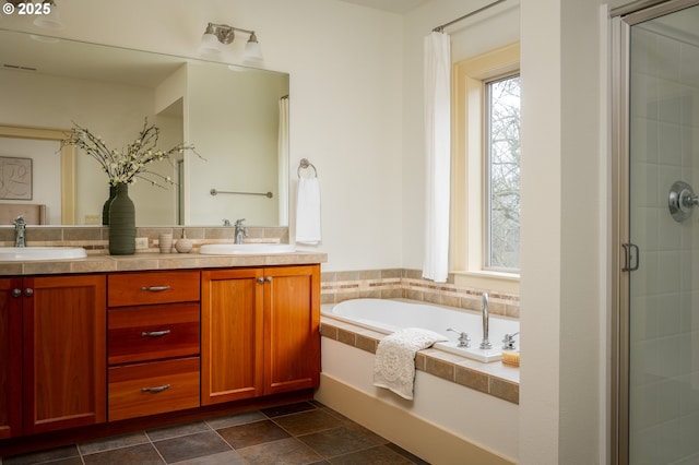 bathroom with a garden tub, a sink, double vanity, and a shower stall