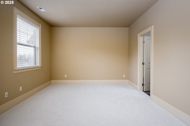 spare room featuring carpet floors and visible vents