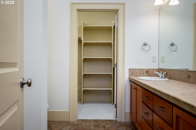 bathroom featuring vanity and a walk in closet