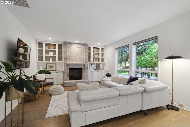 3840 NW Loy Ct, Portland, OR 97229 - living area featuring wood finished floors, a brick fireplace, recessed lighting, and built in features