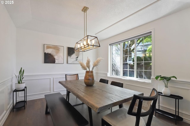 3840 NW Loy Ct, Portland, OR 97229 - dining space featuring dark wood-style flooring, a chandelier, a wainscoted wall, and a decorative wall