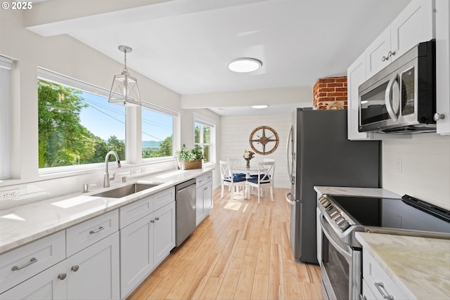 1331 NE Dallas St, Camas, WA 98607 - kitchen featuring stainless steel appliances, a sink, light wood-type flooring, and white cabinets