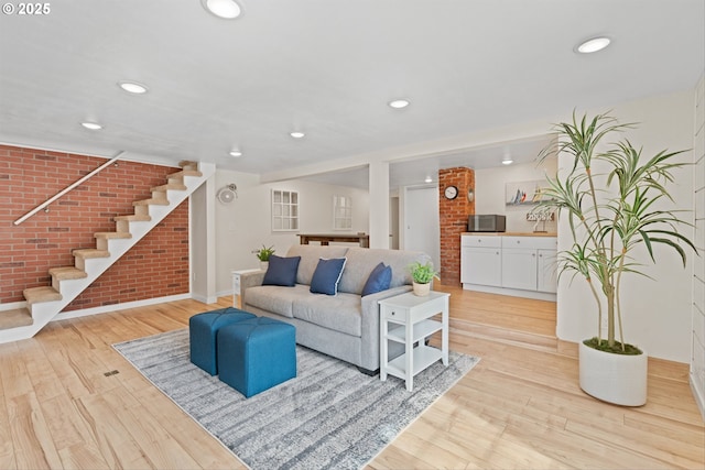 1331 NE Dallas St, Camas, WA 98607 - living room with brick wall, baseboards, stairs, light wood-style flooring, and recessed lighting