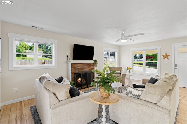 1331 NE Dallas St, Camas, WA 98607 - living room with baseboards, light wood-style flooring, a brick fireplace, and a ceiling fan