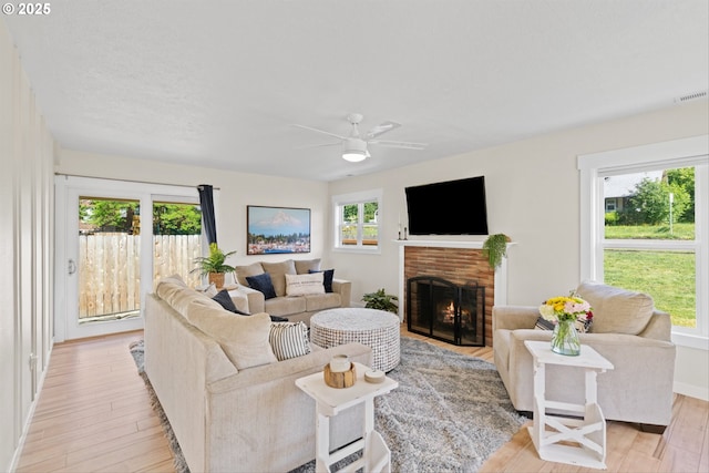 1331 NE Dallas St, Camas, WA 98607 - living room with a brick fireplace, a ceiling fan, light wood-style flooring, and baseboards