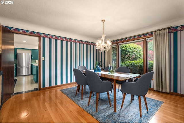 1134 NE Cesar E Chavez Blvd, Portland, OR 97232 - dining room with a chandelier, wood finished floors, and wallpapered walls