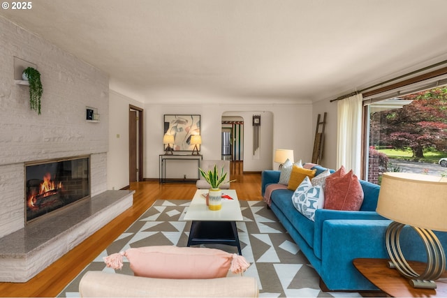 1134 NE Cesar E Chavez Blvd, Portland, OR 97232 - living room with arched walkways, a fireplace, and wood finished floors