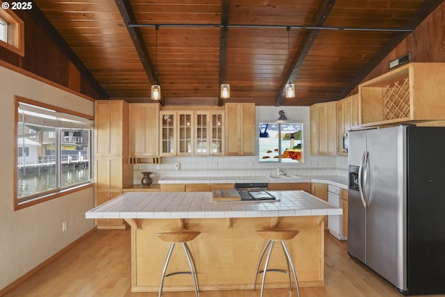 1879 N Jantzen Ave, Portland, OR 97217 - kitchen featuring stainless steel fridge with ice dispenser, wooden ceiling, tile countertops, decorative backsplash, and light wood finished floors