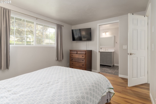 1740 Linnea Ave, Eugene, OR 97401 - bedroom featuring wood finished floors, ensuite bathroom, baseboards, and a sink