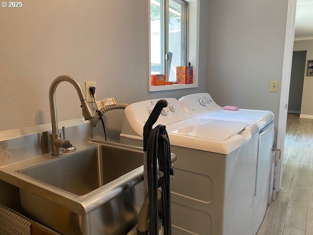 5944 SW Wilbard St, Portland, OR 97219 - laundry room with washer and dryer, light wood finished floors, and baseboards