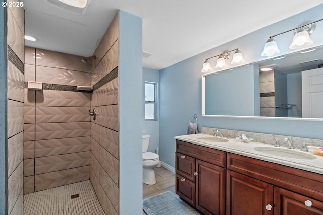 5944 SW Wilbard St, Portland, OR 97219 - bathroom with double vanity, a tile shower, toilet, tile patterned flooring, and baseboards