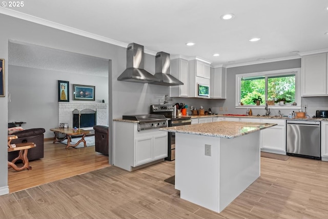 5944 SW Wilbard St, Portland, OR 97219 - kitchen with appliances with stainless steel finishes, wall chimney range hood, a sink, crown molding, and white cabinetry