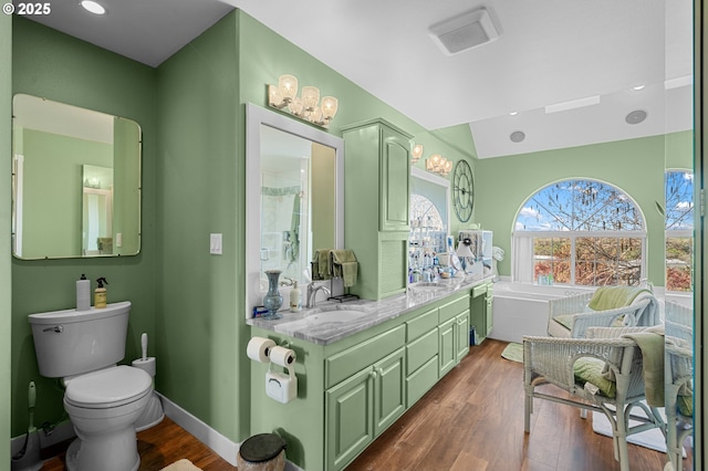 full bathroom with visible vents, baseboards, a sink, a tub to relax in, and wood finished floors