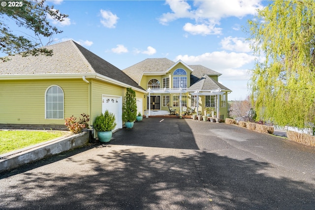 view of front of house featuring a shingled roof, a garage, and driveway