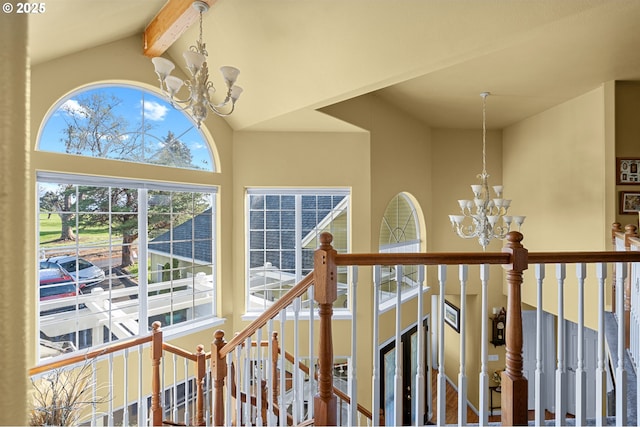 interior space featuring a chandelier, high vaulted ceiling, beamed ceiling, and an upstairs landing