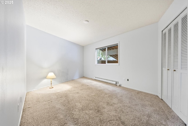 unfurnished bedroom with carpet, a baseboard heating unit, a closet, and a textured ceiling