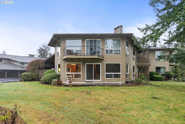 rear view of property with a balcony and a lawn