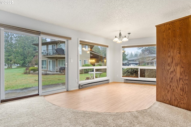 interior space with a baseboard heating unit, a chandelier, and carpet floors