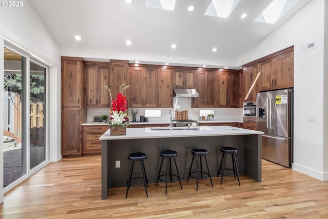 1236 Parkside Ave, Forest Grove, OR 97116 - kitchen with stainless steel fridge, a skylight, backsplash, light wood-type flooring, and recessed lighting