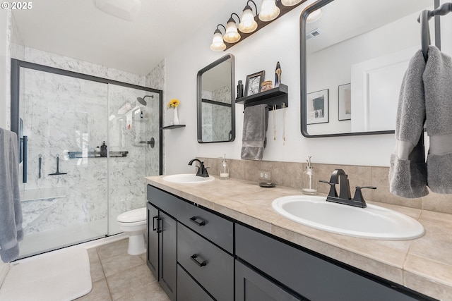4952 SW Wentworth Ter, Beaverton, OR 97078 - bathroom featuring toilet, a marble finish shower, double vanity, and tile patterned floors