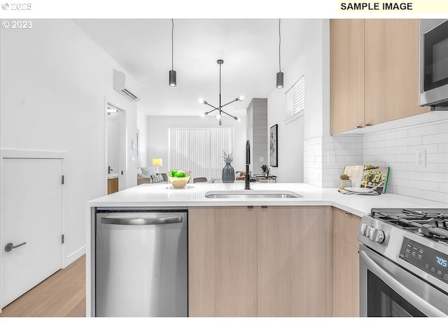 kitchen featuring pendant lighting, light brown cabinetry, sink, a wall mounted AC, and stainless steel appliances