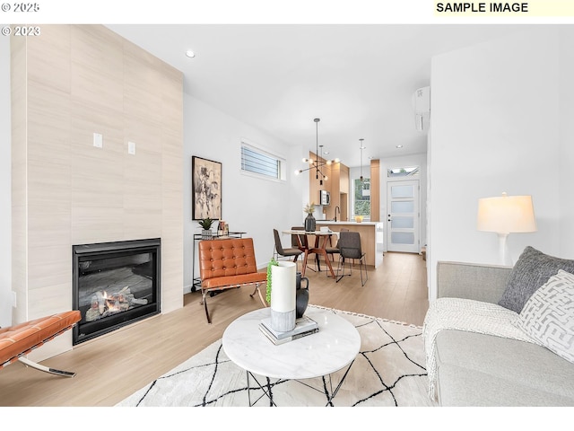 living room with sink, a fireplace, and light hardwood / wood-style flooring