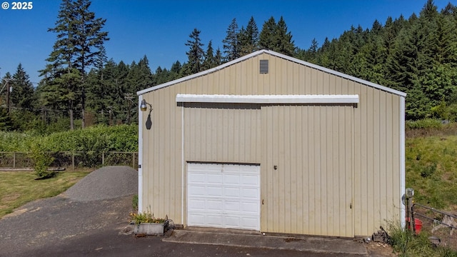 detached garage featuring a wooded view