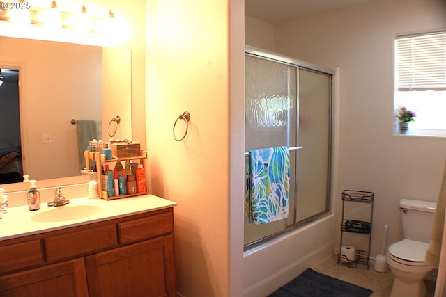 bathroom featuring toilet, vanity, and shower / bath combination with glass door