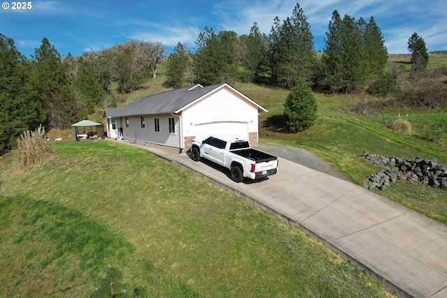 view of front facade featuring an attached garage, a front lawn, and concrete driveway