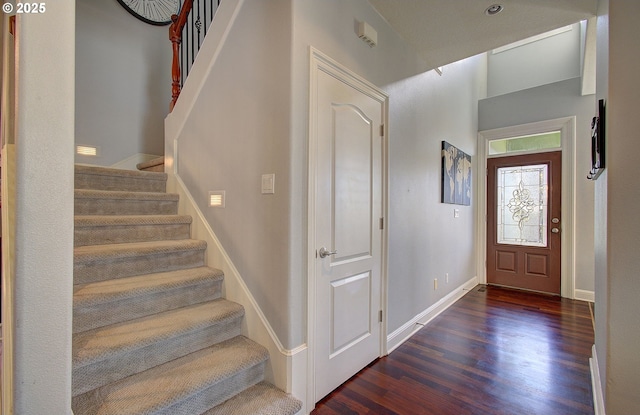 entrance foyer with baseboards, stairs, and wood finished floors