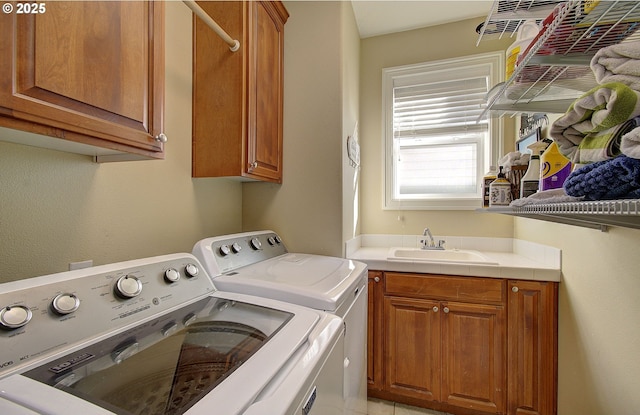 washroom with a sink, separate washer and dryer, and cabinet space